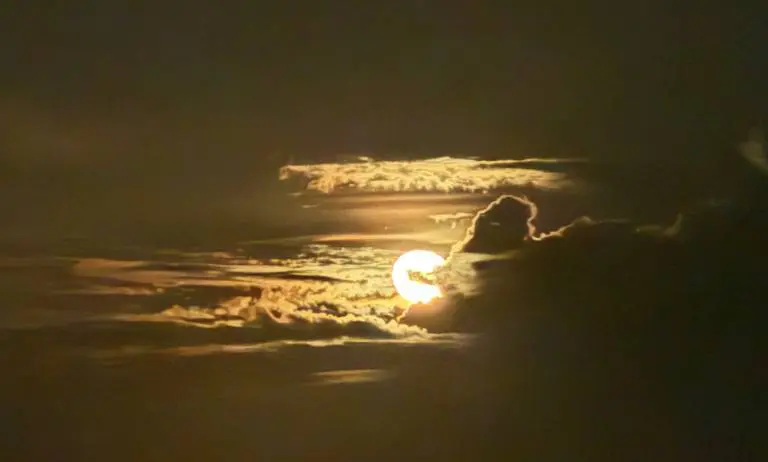 Golden sunset with clouds partly covering the sun.