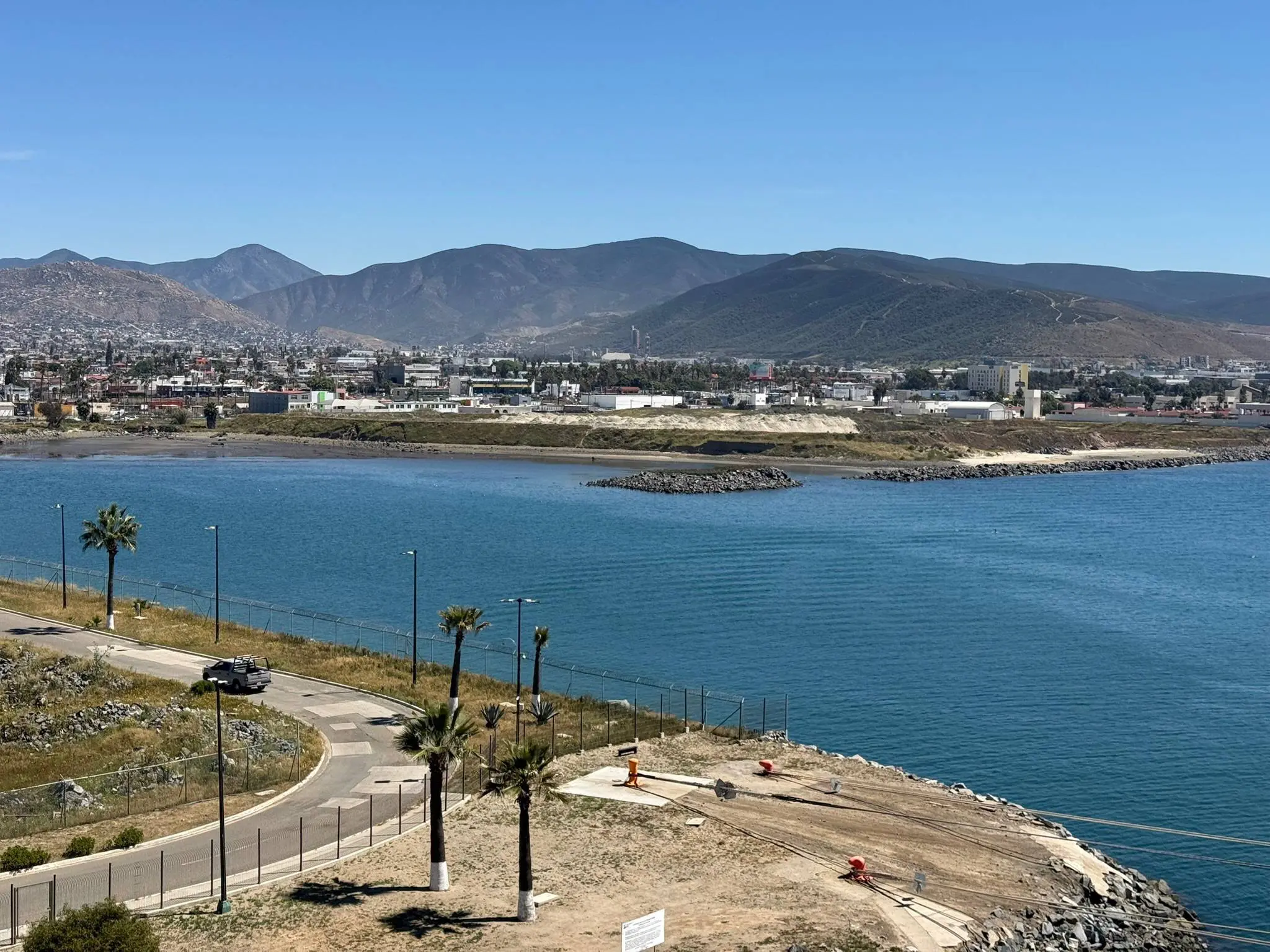Scenic view of a river with a town and mountains in the background.