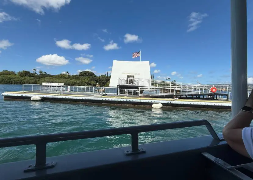 View of a white building by the water under a clear blue sky.